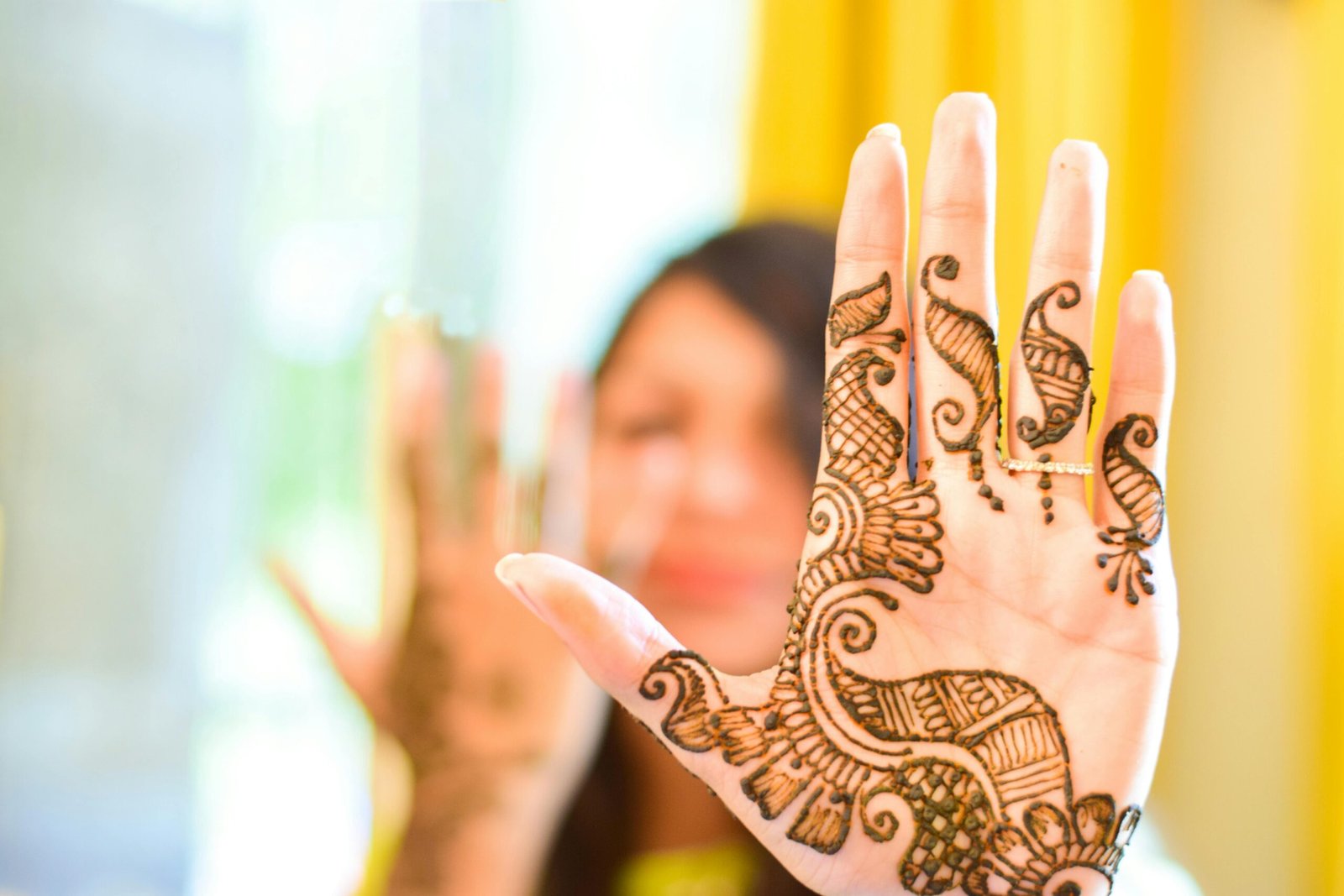 Close-up of a woman's hand with intricate henna design, symbolizing tradition and artistry.